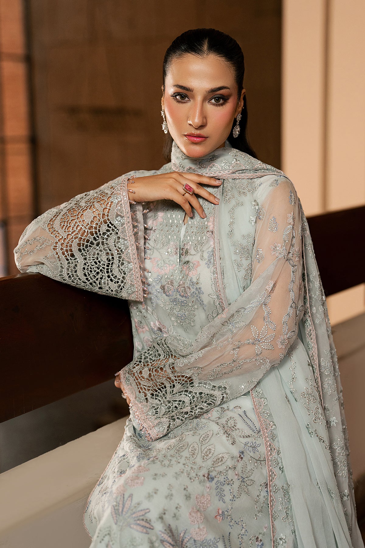 Woman in a light-colored embroidered traditional outfit with a blurred background