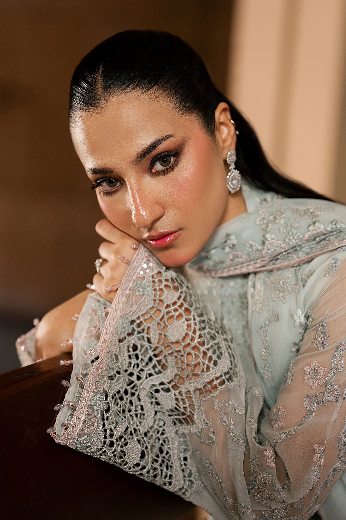 Woman wearing a light blue embroidered traditional outfit with a blurred background